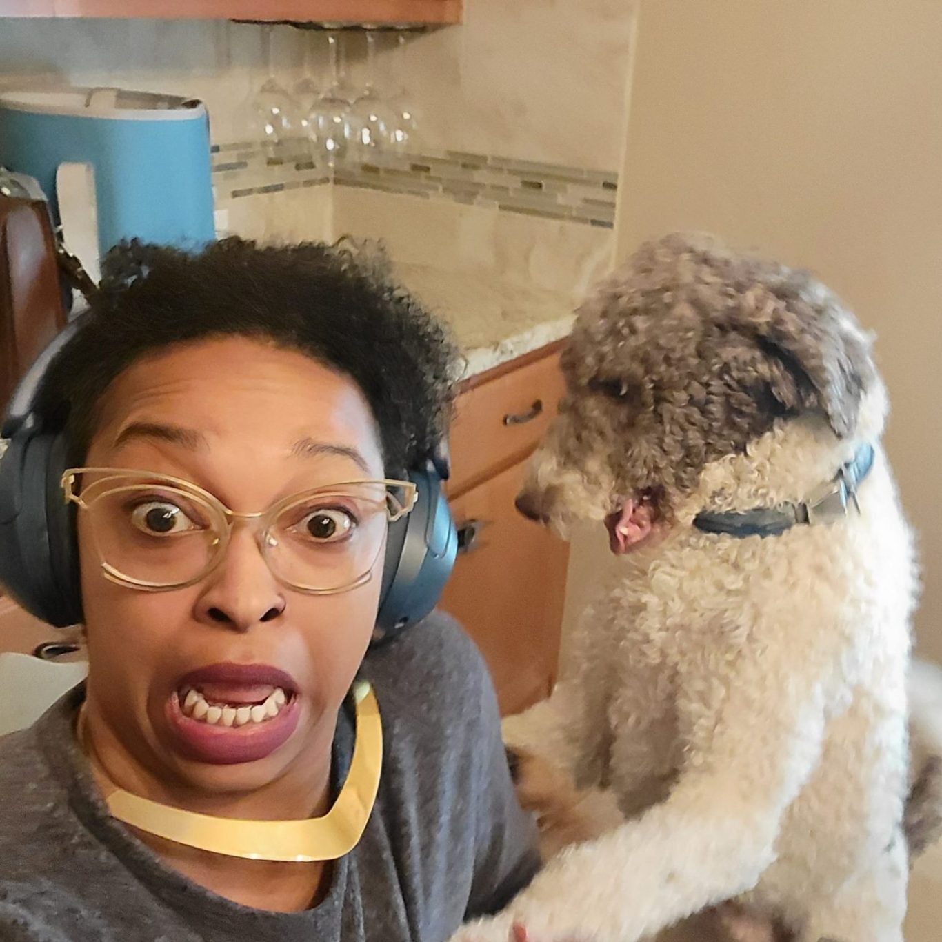 Bre Hart - Owner of You Can Leave Pet Sitting Services in North Austin, Texas Smiling person with curly hair, colorful glasses, and vibrant lipstick.
